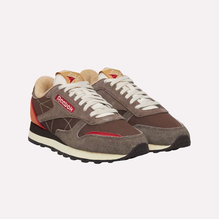 A pair of brown Reebok Classic Leather Premium LTD Shoes with red and beige accents, white laces, and black soles is displayed on a plain white background. These retro sneakers from Reebok feature a classic silhouette that blends timeless style with everyday comfort.