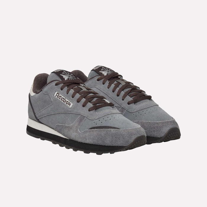 A pair of Reebok Classic Leather Premium LTD Shoes in gray, featuring black laces and soles with contrasting white midsoles. Displaying a timeless silhouette, these retro sneakers are arranged side by side against a plain white background.