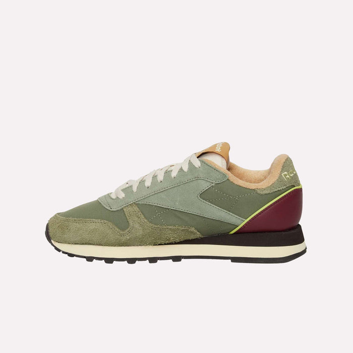 The Reebok Classic Leather Premium LTD Shoes display retro charm with their green and beige design, white laces, dark red heel accent, and black-and-white sole, all set in a timeless silhouette against a plain light background.
