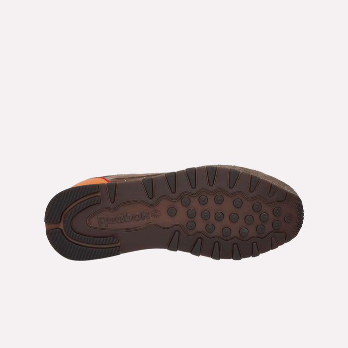 The image displays the brown rubber outsole of the Reebok Classic Leather Premium LTD Shoes, featuring circular grip patterns and the embossed Reebok logo near the center. The timeless silhouette is photographed against a plain light background, emphasizing this iconic pair of retro sneakers.