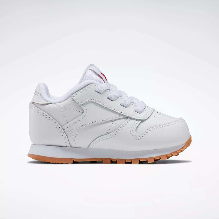 The Reebok Kids' Classic Leather Shoes for babies and toddlers feature white laces and a light brown rubber sole, shown against a plain white background.