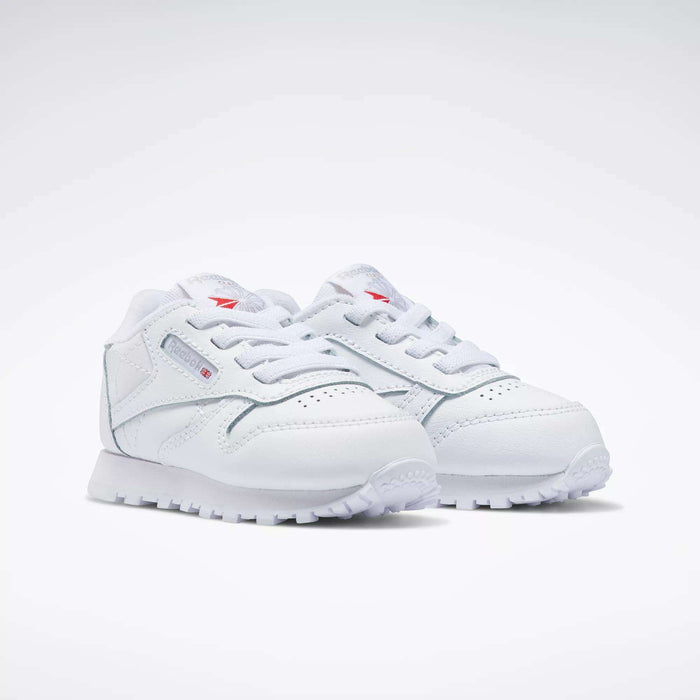 The Reebok Kids' Classic Leather Shoes – Baby & Toddler—white with laces and subtle side and tongue branding—are shown on a plain white background, offering timeless style for little ones.