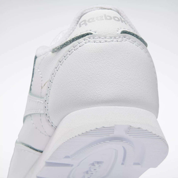 Close-up of the heel on Reebok Kids' Classic Leather Shoes – Baby & Toddler, featuring textured stitching, part of the outsole, and an embossed Reebok logo—ideal for little ones’ daily adventures.