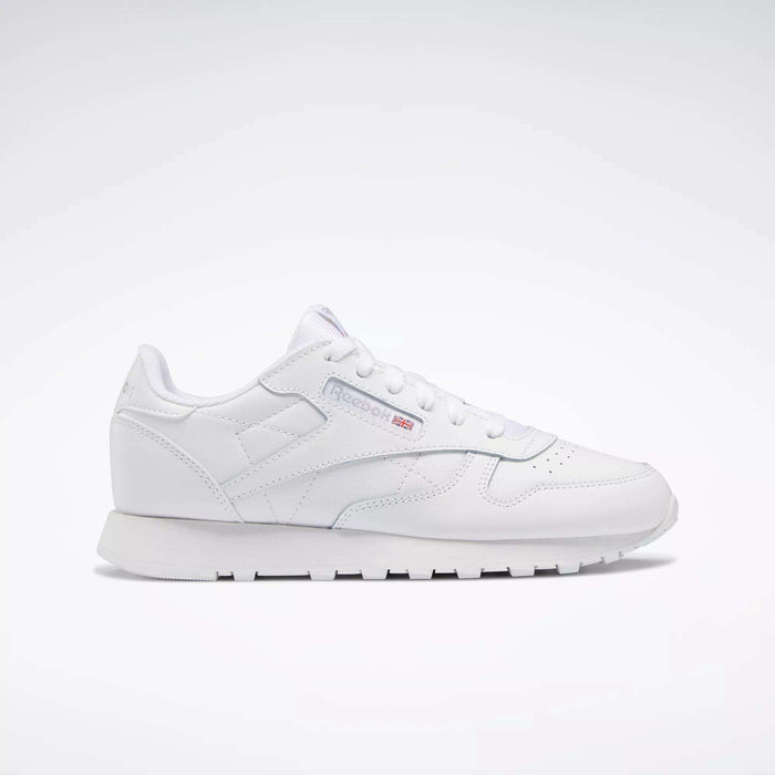 The Reebok Classic Leather Shoes - Big Kids feature an all-white, low-top design with lace-up closure, subtle side branding, and a flat rubber sole—perfect for adding minimalist style to any junior boys' shoe collection.
