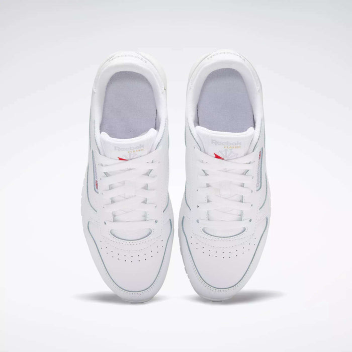 A pair of Reebok Classic Leather Shoes for big kids in white, viewed from above with both shoes side by side, laces tied, and subtle branding on the tongues—a timeless design.