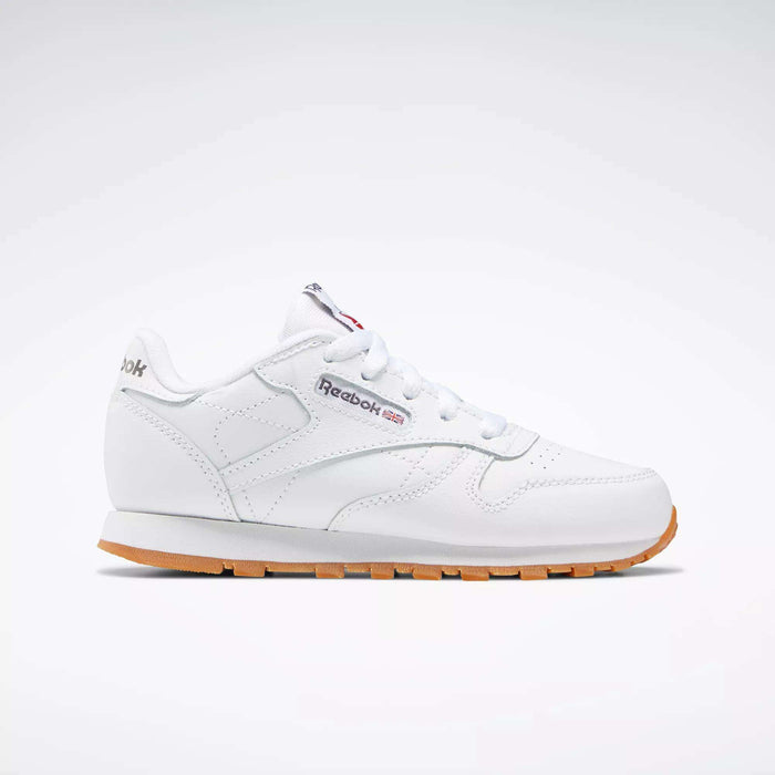 The Reebok Kids' Classic Leather Shoes - Preschool are shown in profile with a white leather upper, gum sole, white laces, stitching details, and the Reebok logo with a Union Jack flag on the side against a plain light background.