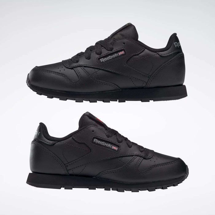 Two black Reebok Kids' Classic Leather Shoes - Preschool with black laces are shown from the side on a white background, highlighting their leather upper and lightweight cushioning for all-day comfort.