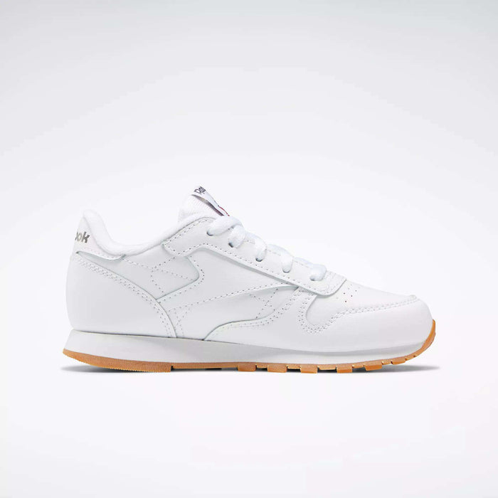 The Reebok Kids' Classic Leather Shoes - Preschool are white sneakers with a gum rubber sole and lightweight cushioning, displayed in side profile against a plain light gray background.