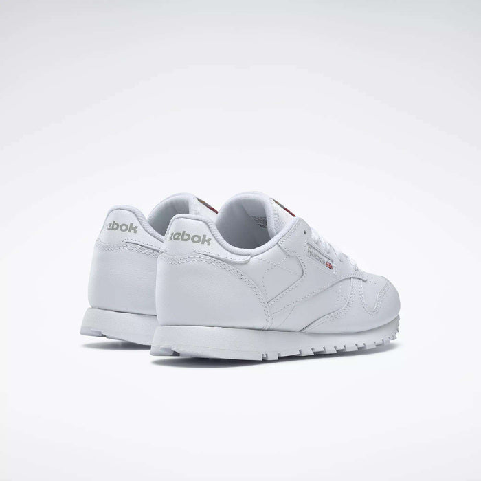 The Reebok Kids' Classic Leather Shoes - Preschool feature a white leather upper, subtle branding, and a clean, minimalist design. Displayed on a white background, the shoes are shown from the back and side angles.