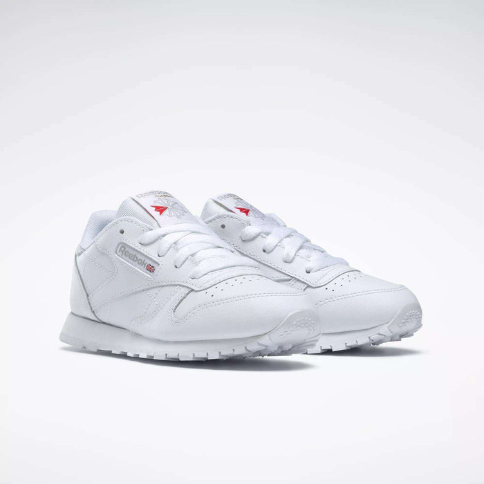 Reebok Kids' Classic Leather Shoes - Preschool feature a white leather upper, white laces, side Reebok logo, and textured rubber soles, shown against a simple light background.