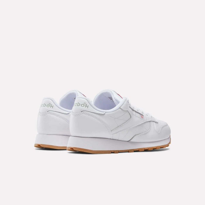 A pair of Reebok Classic Leather Shoes, featuring a leather upper and gum soles, are shown from back and side angles, highlighting their retro style against a plain white background.