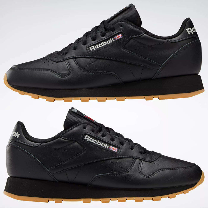 Two black Reebok Classic Leather Shoes with durable leather uppers and tan rubber soles, shown from the side. The Reebok logo and Union Jack are displayed near the laces.
