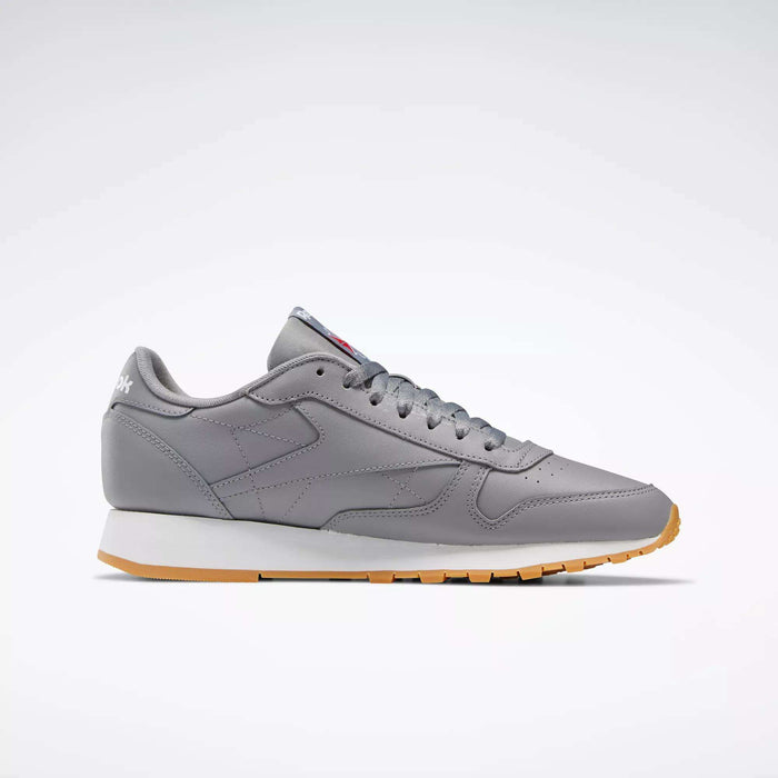 Side view of Reebok Classic Leather Shoes in gray, featuring a white midsole, light brown outsole, and durable leather upper, shown against a plain white background.