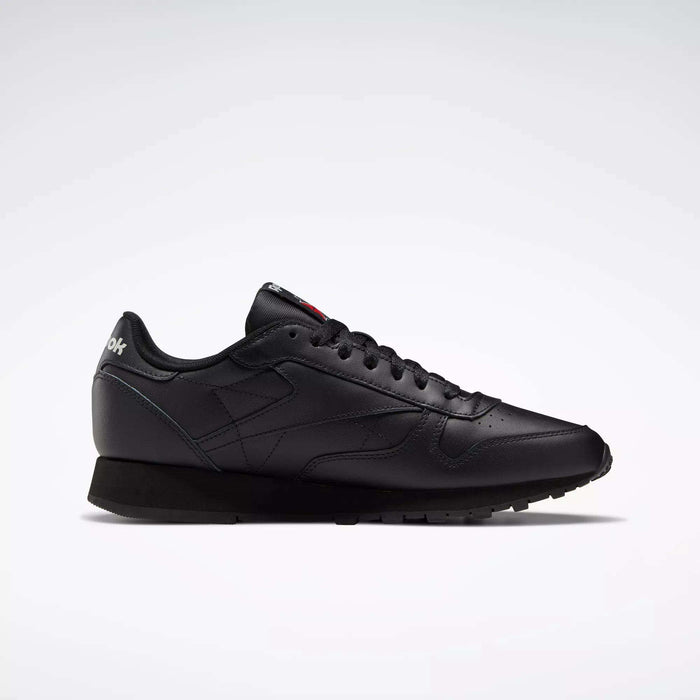 A side profile of the Reebok Classic Leather Shoes is shown on a white background, featuring a sleek black design with matching laces, stitching accents, and a durable leather trainer sole.