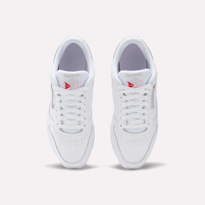 A top view of Reebok Classic Leather Shoes shows a leather upper with laces, perforated toes, and red Reebok logos on the tongues, offering a timeless retro style.
