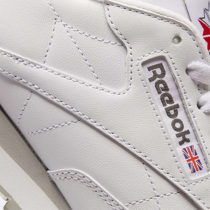 Close-up of Reebok Classic Leather Shoes, showcasing durable leather, precise stitching, the iconic Reebok logo, and a subtle Union Jack flag for timeless retro appeal.