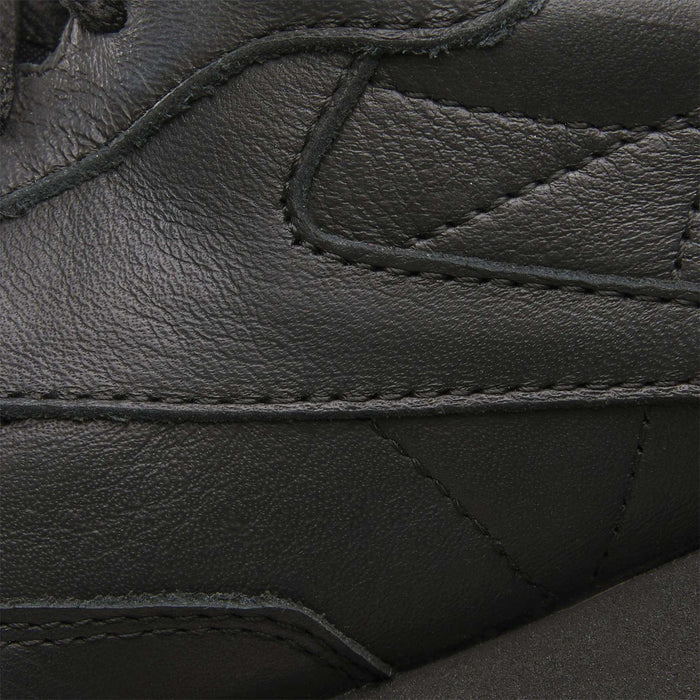 Close-up of Reebok Classic Leather Shoes in black, highlighting the detailed stitching, durable leather texture, and retro style with overlapping panels.