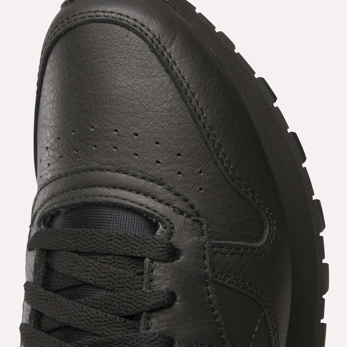 Close-up of the toe and laces of Reebok Classic Leather Shoes, highlighting stitching, ventilation perforations, and textured rubber sole for a retro-inspired look with a durable leather upper.