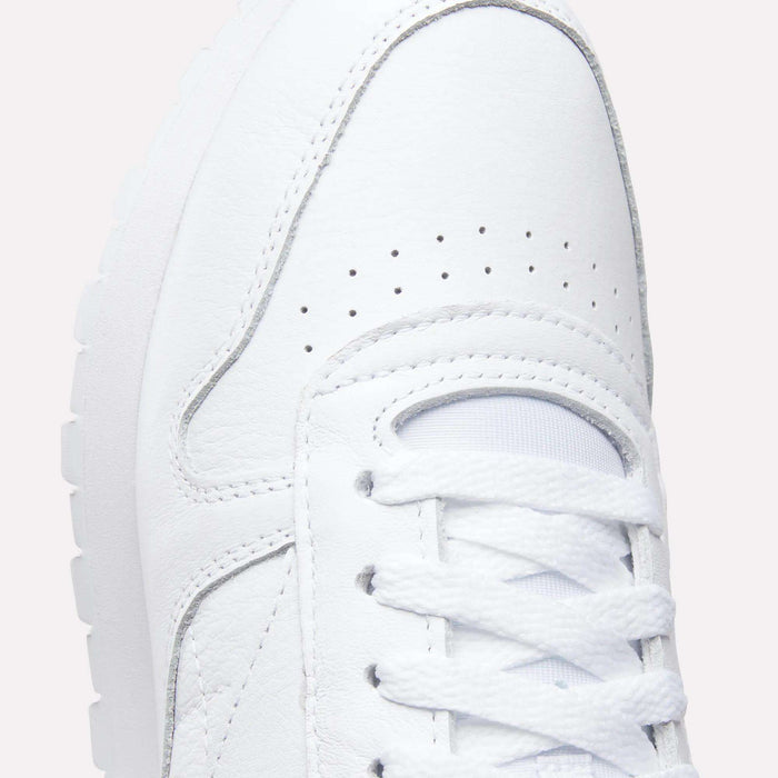 Close-up of the upper part of the Reebok Classic Leather Shoes, featuring laces, detailed stitching, breathable perforations, a durable leather upper, and a glimpse of the textured rubber sole for a retro-inspired look.