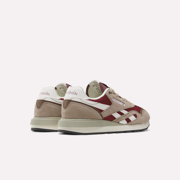 A pair of Reebok Classic Nylon 89 Shoes in beige, maroon, and white are shown angled backward, highlighting the Reebok branding on the heel and side against a plain white background.