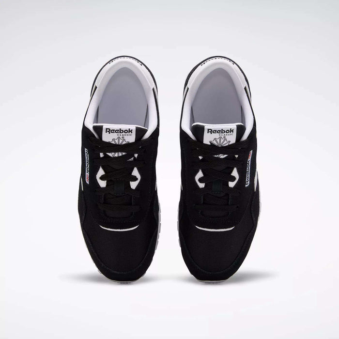 A pair of Reebok Classic Nylon Shoes - Big Kids in black with white soles and accents, inspired by '80s running styles, shown from above on a plain white background. The visible tongue and side logos highlight the Reebok brand.