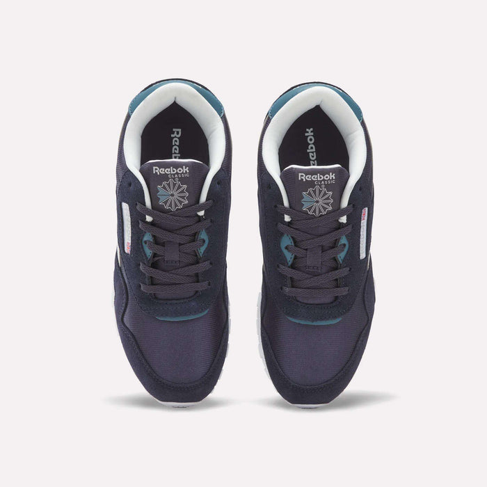 A pair of Reebok Classic Nylon Shoes - Big Kids in navy blue with white soles, seen from above. These boys’ shoes showcase teal accents, white lining, and feature the Reebok logo and star on the insoles.