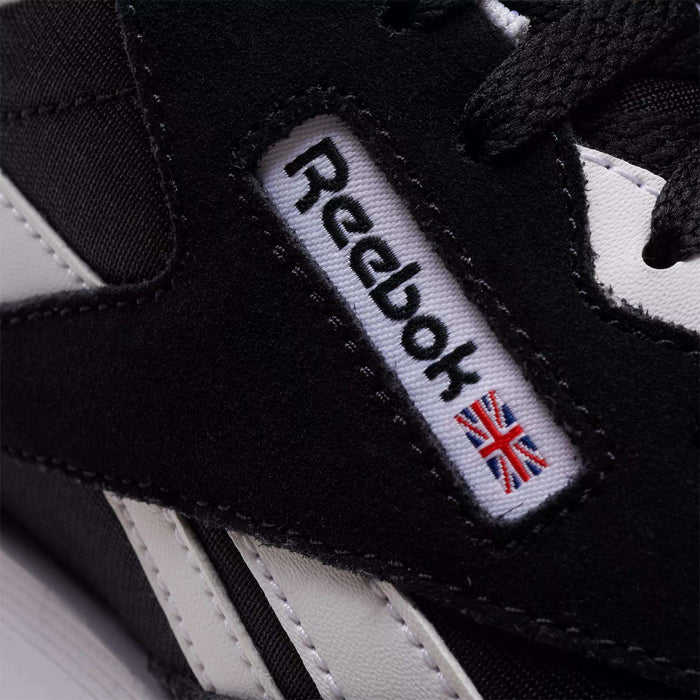 Close-up of Reebok Classic Nylon Shoes - Big Kids in black and white, showing a minimalist design with the embroidered Reebok logo and a small Union Jack flag on a side fabric label, inspired by classic 80s running styles.
