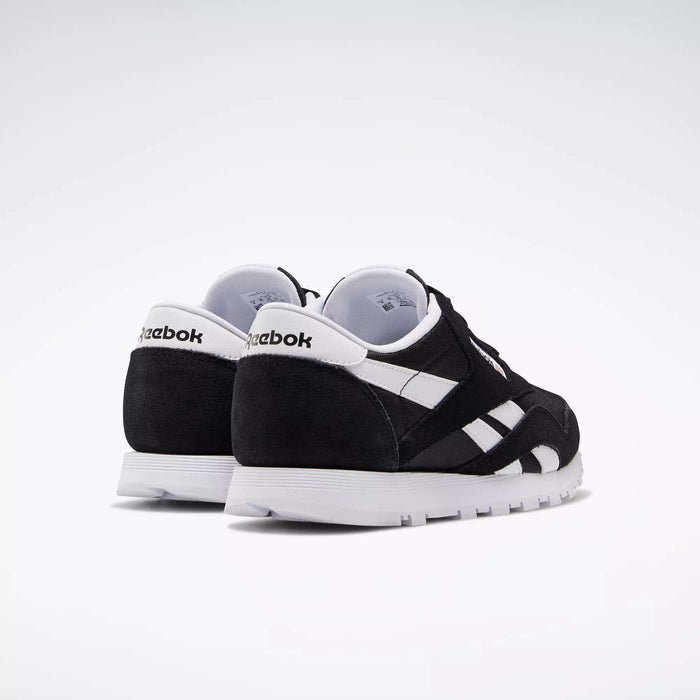 A pair of Reebok Classic Nylon Shoes - Big Kids are angled on a white background to show the back and side views, featuring black and white colors, crisp white soles, and the iconic Reebok logo.