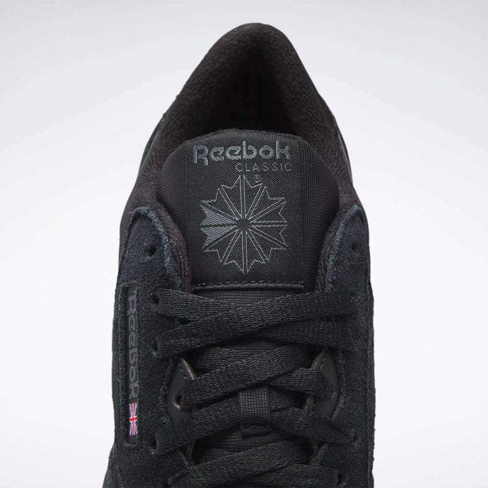 A close-up of Reebok Men's Classic Nylon Shoes features a black nylon upper, black laces, Reebok logo and starburst on the tongue, and a small UK flag on the side—timeless sneakers from Reebok.