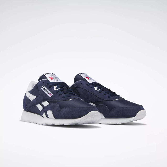 A pair of Reebok Men's Classic Nylon Shoes in navy blue, featuring a nylon upper, white soles, and white detailing, are displayed on a plain white background.