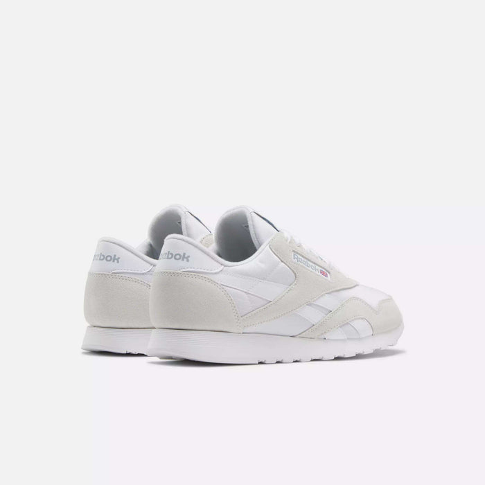 A pair of Reebok Men's Classic Nylon Shoes in white with light gray suede accents are displayed against a plain white background, showing both the side and back views—ideal for everyday wear.