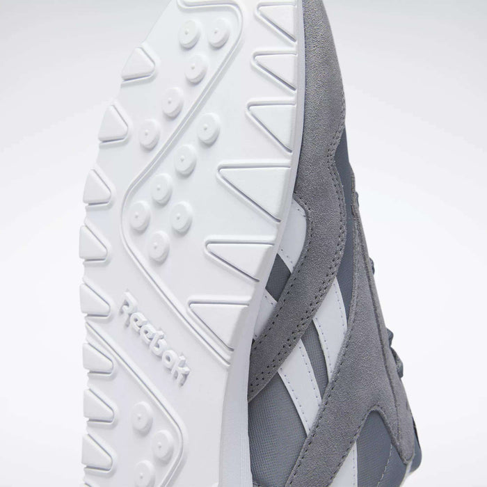 Close-up of the underside of Reebok Men's Classic Nylon Shoes in gray and white, highlighting the textured white rubber sole with Reebok logo, gray nylon upper, and iconic side stripes—timeless sneakers for everyday wear.