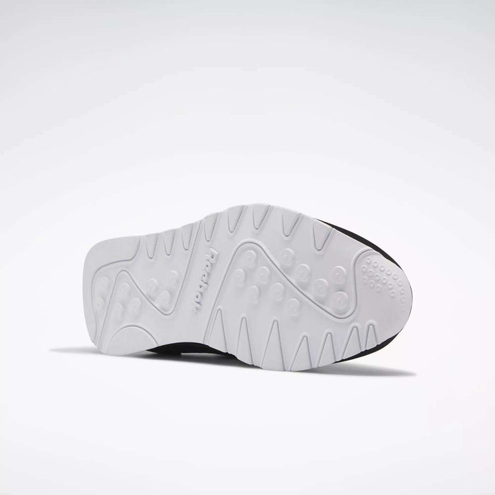 The image displays the white, textured sole of Reebok Men's Classic Nylon Shoes with circular grips and patterns—an excellent everyday sneaker—set against a plain, light background.