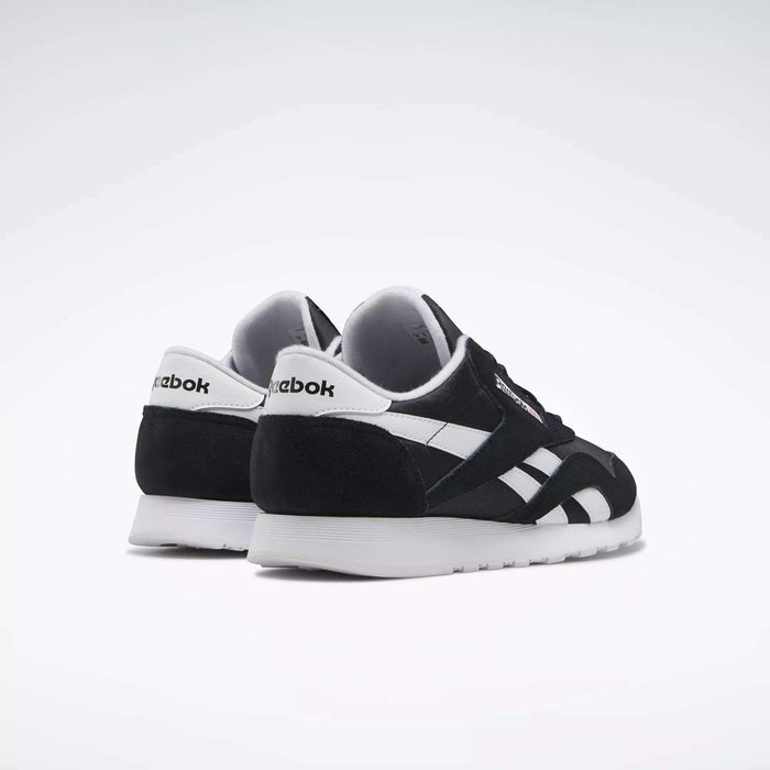A pair of Men's Classic Nylon Shoes by Reebok in black and white, set on a white background with one shoe behind the other, showcasing side and back views—classic everyday sneakers with timeless style.