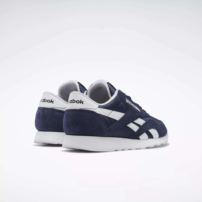The Men's Classic Nylon Shoes by Reebok are everyday navy blue sneakers with a nylon upper, white accents, and white soles. Shown angled on a white background, the Reebok logo appears on the heel and side.