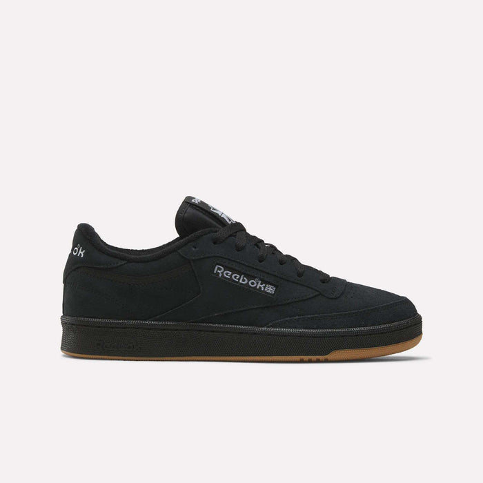 The Reebok Club C 85 Shoes feature a low-profile black suede upper, black sole, gum outsole, and a white Reebok logo on the side, shown against a plain light background.