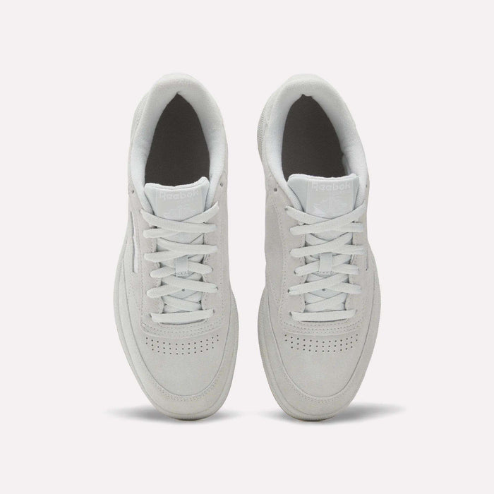 A top-down view of Reebok Club C 85 Shoes in white, showcasing clean laces, a suede upper, toe perforations, and light gray soles on a plain white background.