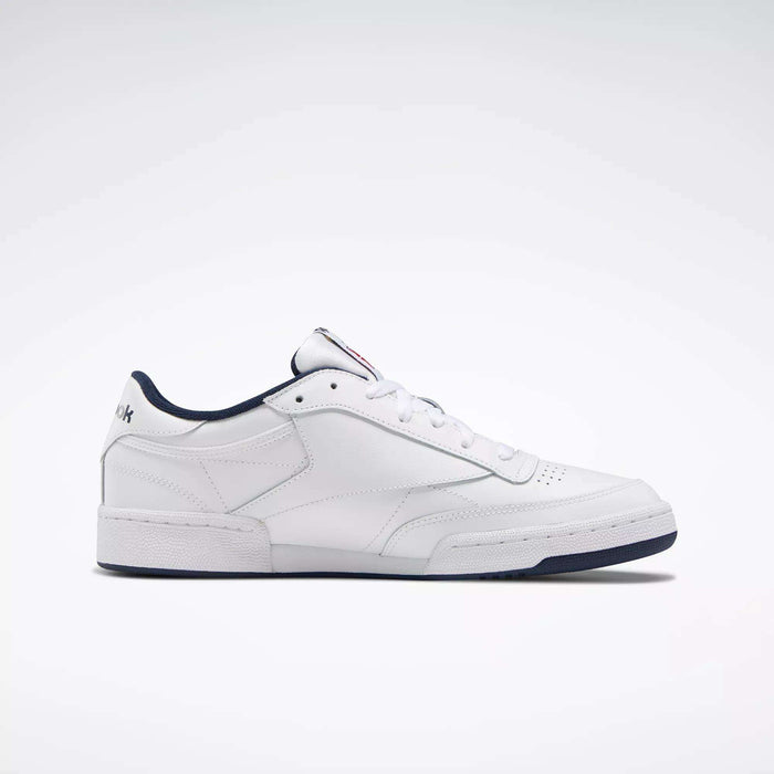The Reebok Club C 85 Shoes are white low-top leather sneakers inspired by classic tennis style, featuring a dark blue sole and trim, simple stitching, and subtle branding on the heel and tongue.