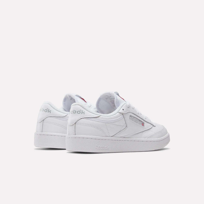 A pair of Reebok Club C 85 Shoes in white leather with subtle silver and red logo accents, shown on a white background at an angle highlighting both the side and back views.