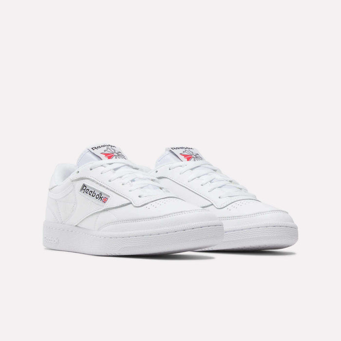 A pair of Reebok Club C 85 Shoes in white leather with low tops, showing the Reebok logo and Union Jack on the side. Inspired by classic tennis styles, displayed against a plain white background.