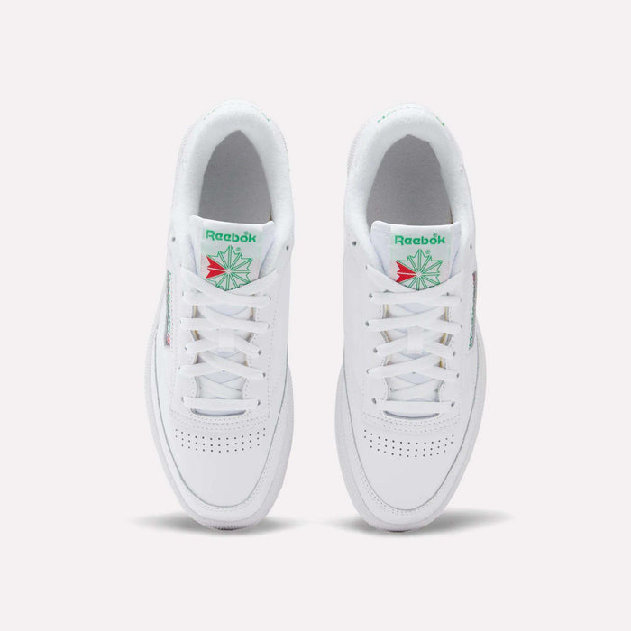 Top view of Reebok Club C 85 Shoes, featuring white leather, perforated toe, white laces, and green and red logo details on the tongue. The tennis-inspired sneakers are placed side by side on a light background.