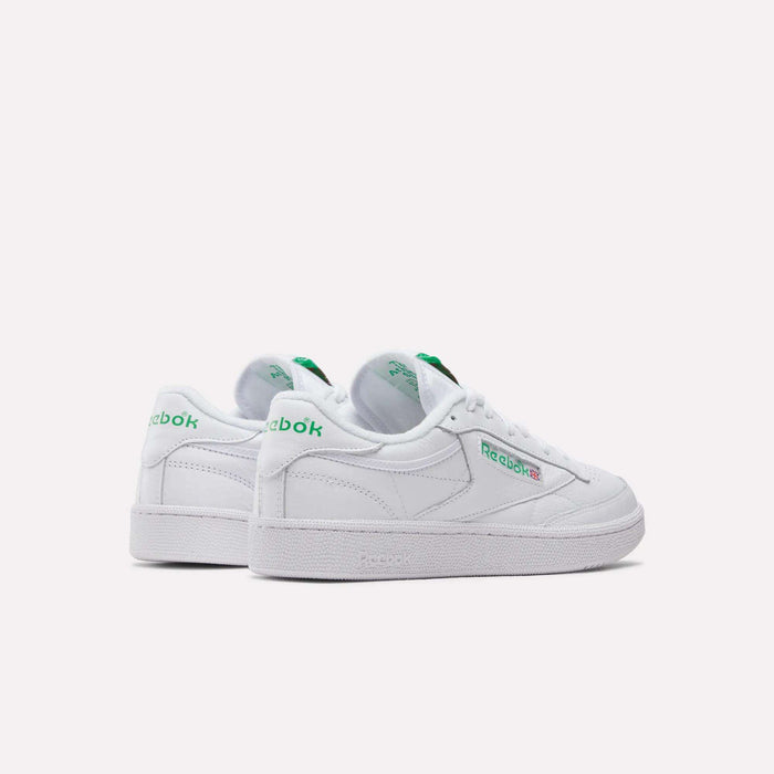 A pair of Reebok Club C 85 Shoes in white leather with green branding, shown from the back and side on a plain light background. These tennis-inspired sneakers feature a classic low-top design and white soles.