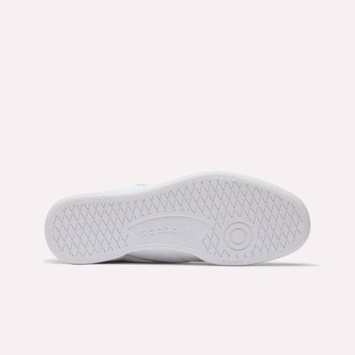 The bottom view of the white Reebok Club C 85 Shoes shows a zigzag tread pattern, a circular grip by the toe, and an embossed Reebok logo in the center, highlighting these classic leather sneakers.