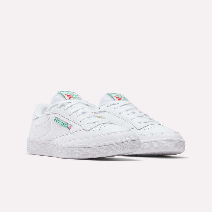 A pair of Reebok Club C 85 Shoes in white leather with green and red logo accents, shown on a plain white background. These tennis-inspired sneakers have a classic low-top design and perforated toe detailing.