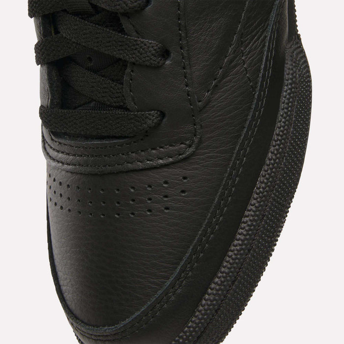 Close-up of the toe area of Reebok Club C 85 Shoes, featuring black leather, black laces, a textured rubber sole, visible stitching details, and small perforations on the upper.