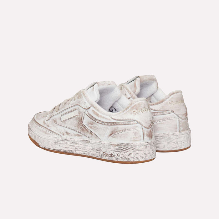 A pair of Reebok Club C 85 Vintage LTD Shoes in white with beige accents, seen from the back and side on a simple light background—an effortlessly cool update to a classic lifestyle tennis sneaker.