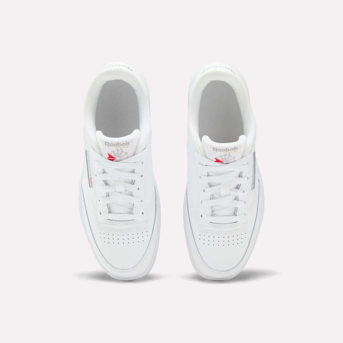 The Reebok Club C Double Shoes for big kids feature a leather upper, white laces, and a red Reebok logo on the tongue—seen from above on a light background—making them the perfect classic girls' shoes.