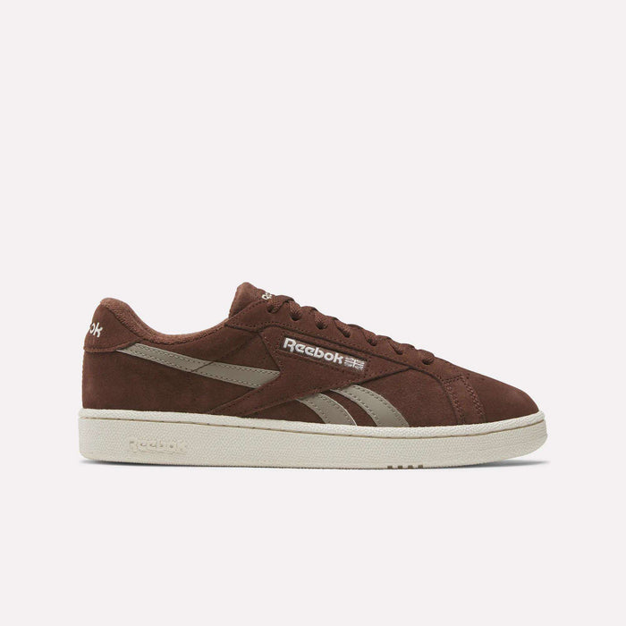 The Reebok Club C Grounds UK Shoes feature a brown suede upper, beige accents, and a beige sole. The Reebok logo appears on the side and heel. Shown in a side view against a plain white background.