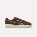 The Reebok Club C Grounds UK Shoes feature a brown suede upper, beige accents, and a beige sole. The Reebok logo appears on the side and heel. Shown in a side view against a plain white background.