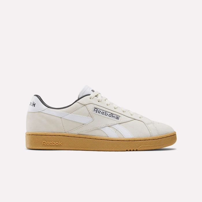 The Reebok Club C Grounds UK Shoes in beige premium suede feature white stripes and logo, white laces, and a gum-colored sole for a classic look—all set against a plain white background.